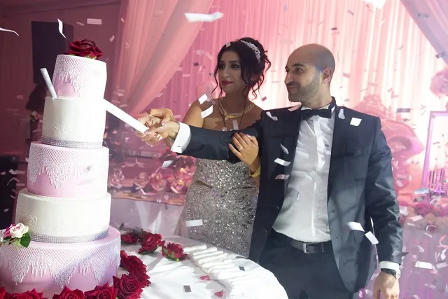 Wedding cake – the bride and groom and DJ Pouriya Persian bride and groom cut the wedding cake