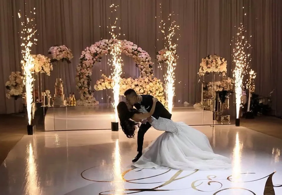Hochzeitspaar posiert vor einer Pyroshow bei ihrer Feier