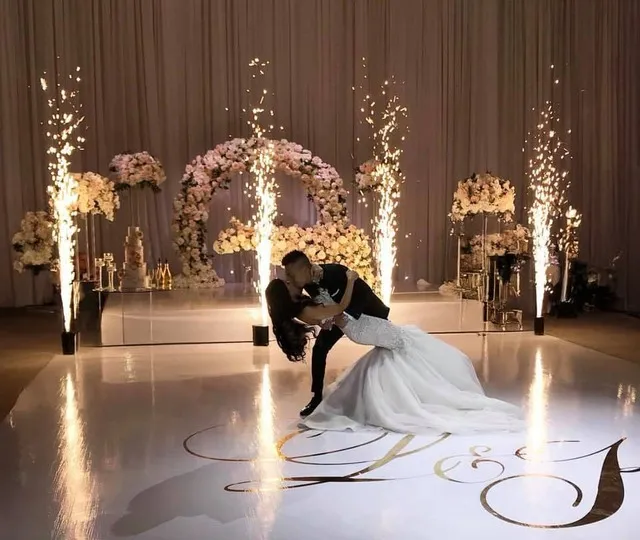 Hochzeitspaar posiert vor einer Pyroshow bei ihrer Feier
