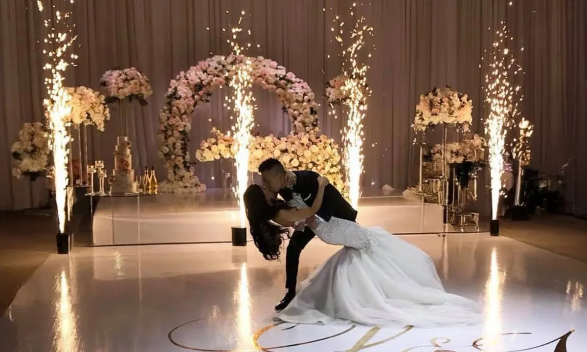 Bride and groom in front of an impressive pyrotechnic display Newlyweds pose in front of a pyrotechnic display at their celebration.
