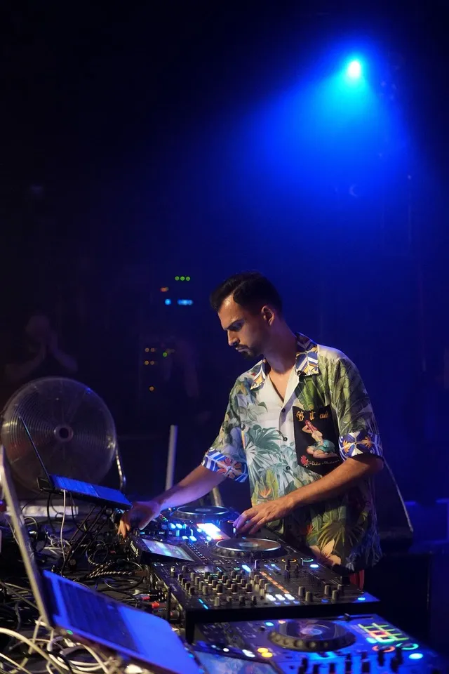 DJ Pouriya mit Kopfhörern am Mischpult